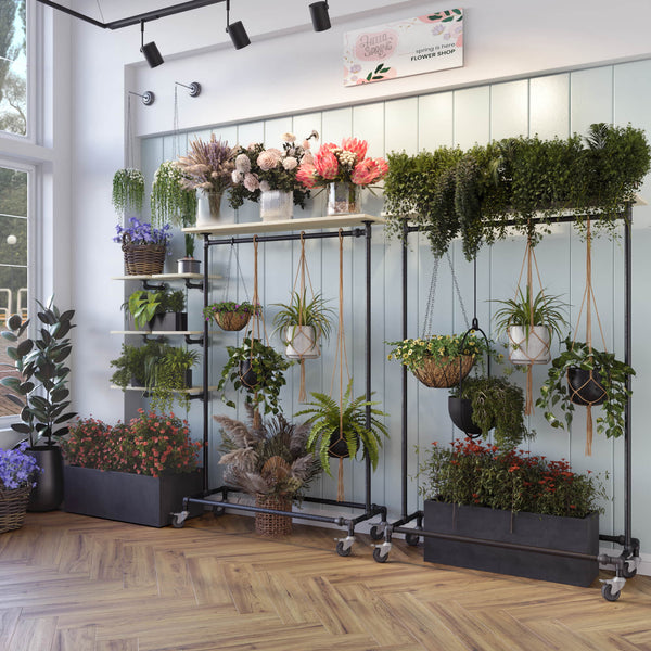Tøjstativ i mørke vandrør på hjul og med tophylde til blomsterophæng / blomster butik